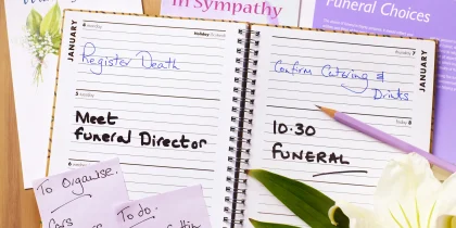 funeral plans in an open planner with flower and sticky notes