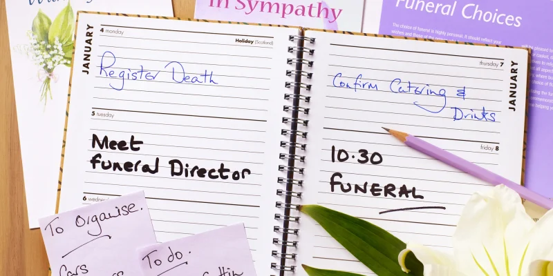 funeral plans in an open planner with flower and sticky notes