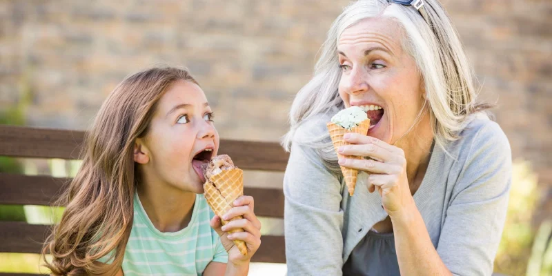 grandma and granddaughter eating ice cream outside