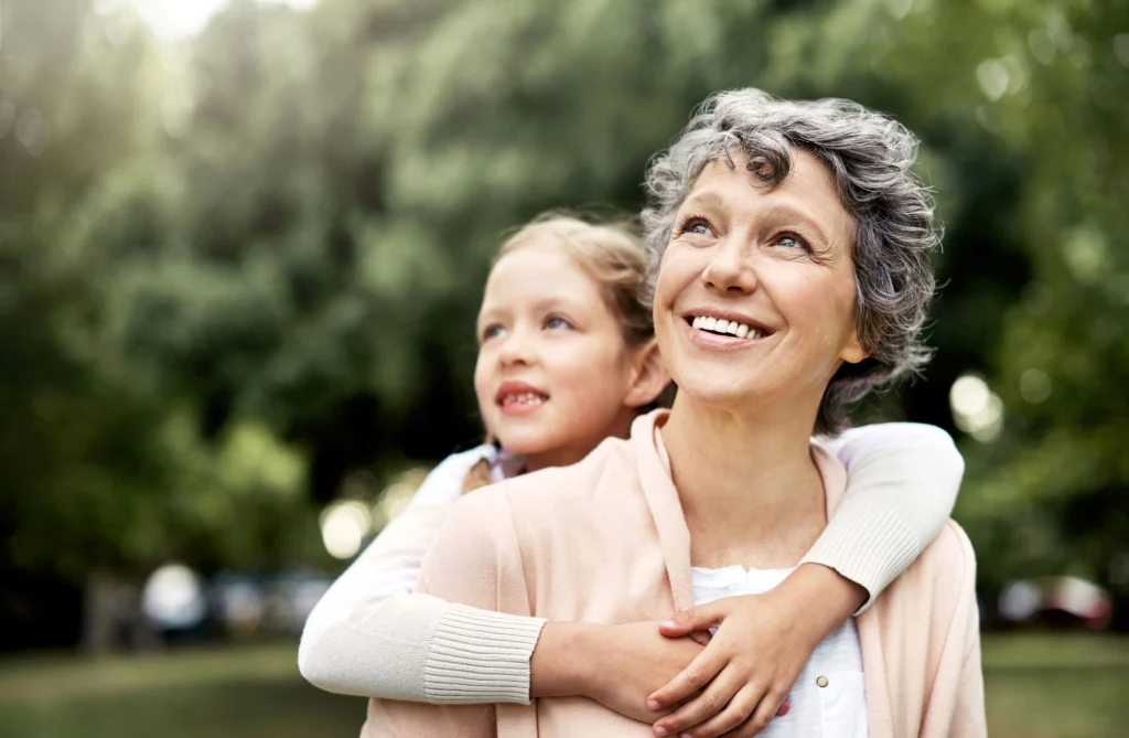 grandma and granddaughter smiling in the sun