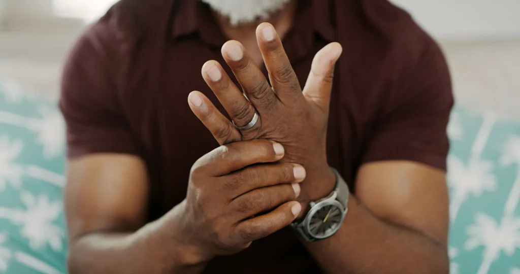 Cropped shot of an unrecognizable man sitting alone on his sofa at home and suffering from arthritis in his hand trying to manage inflammation