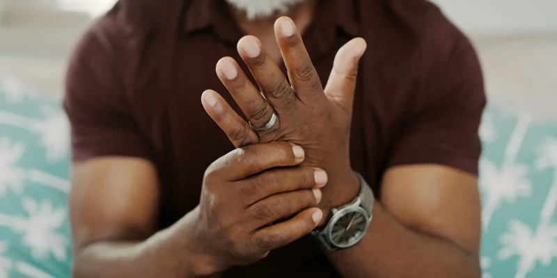 Cropped shot of an unrecognizable man sitting alone on his sofa at home and suffering from arthritis in his hand trying to manage inflammation