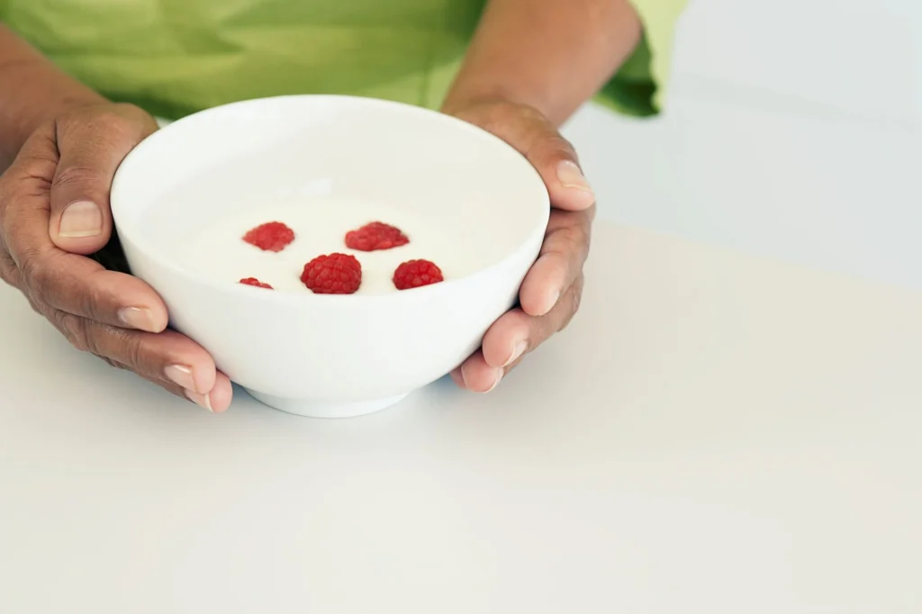 hands holding a bowl of yogurt
