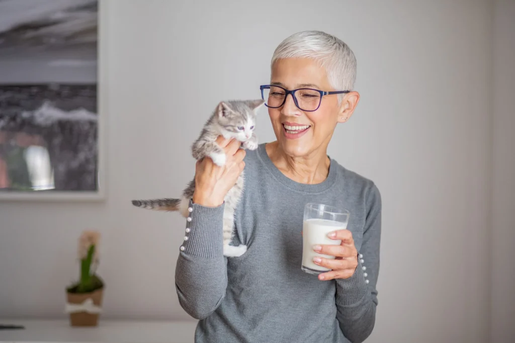 older lady with a kitten and milk