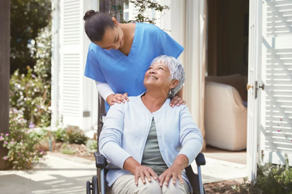 older lady in a wheelchair outside with her caregiver home care