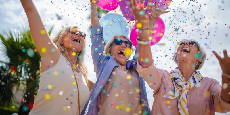 older women celebrating with colorful balloons