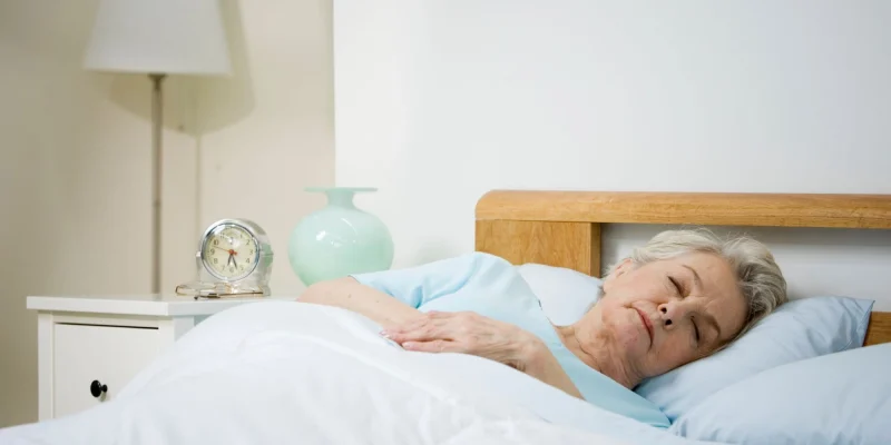 older woman sleeping in her bed