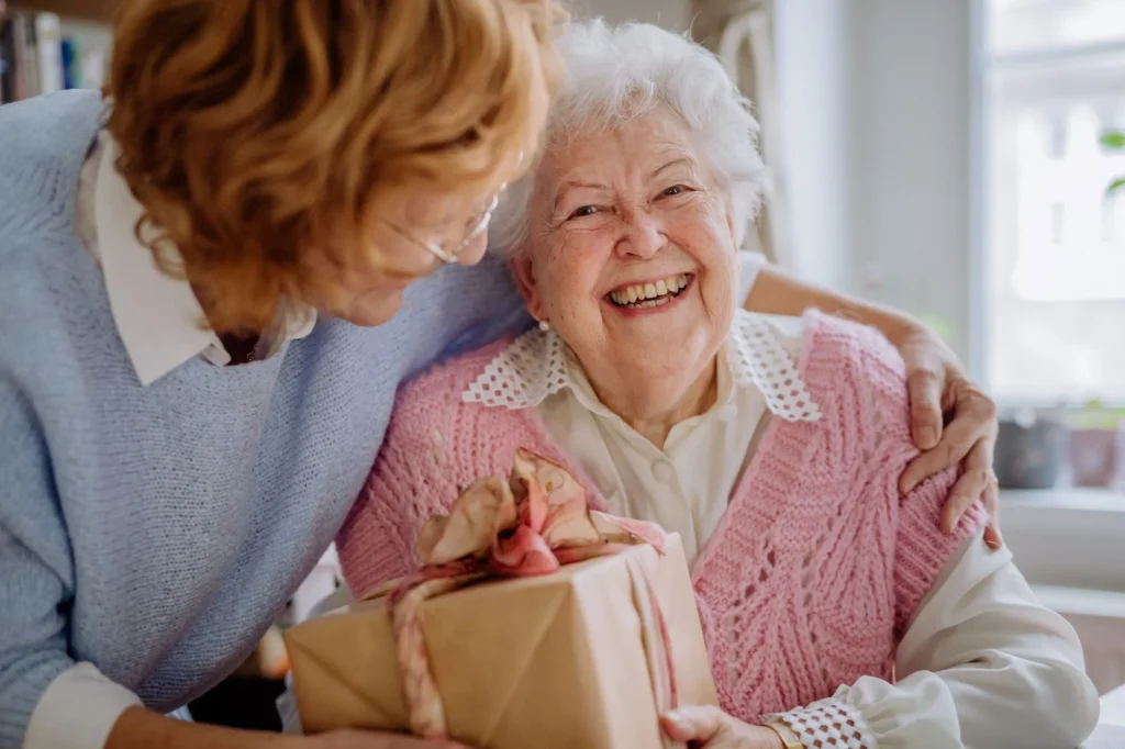 older lady receiving a present from mature daughter