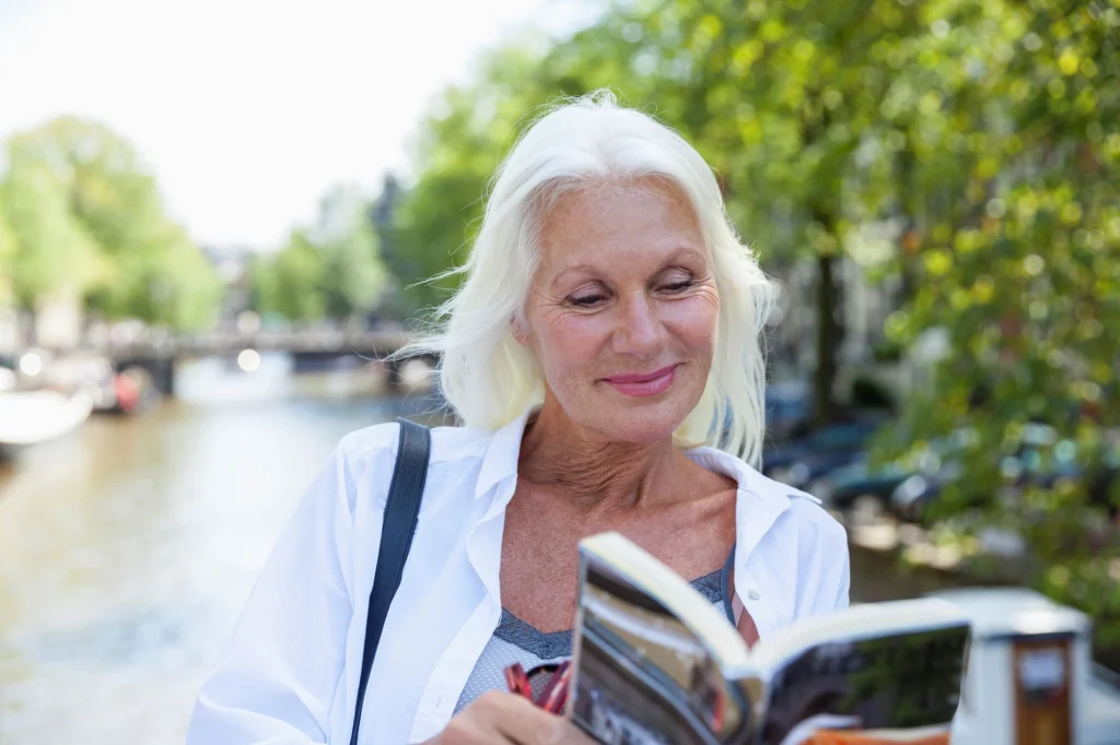 older woman reading on trip