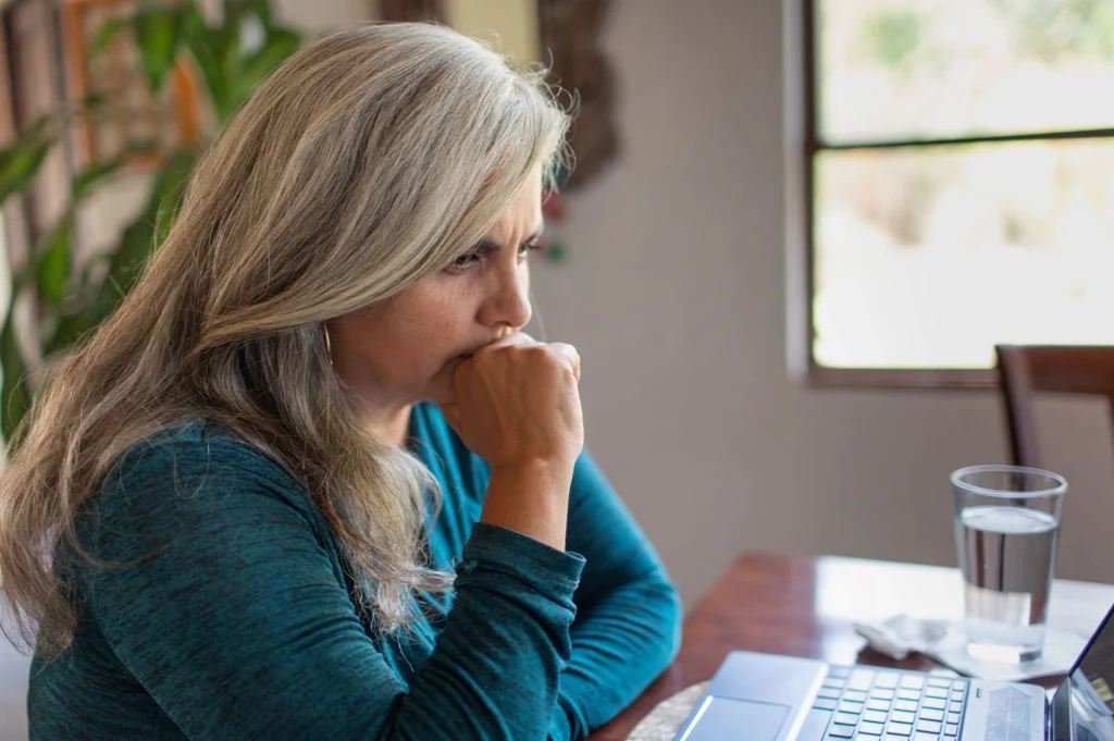 lady in a blue shirt staring at a laptop