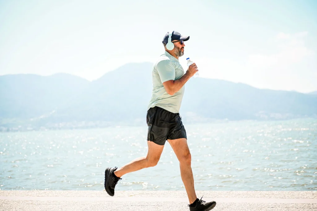 race walking senior man wearing headphones outside