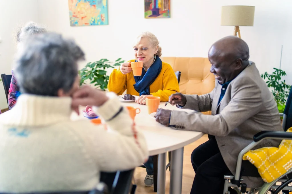 retirees drinking tea and enjoying dessert around a table