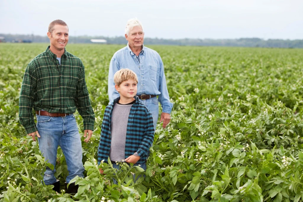 three generations of farmhands in a field