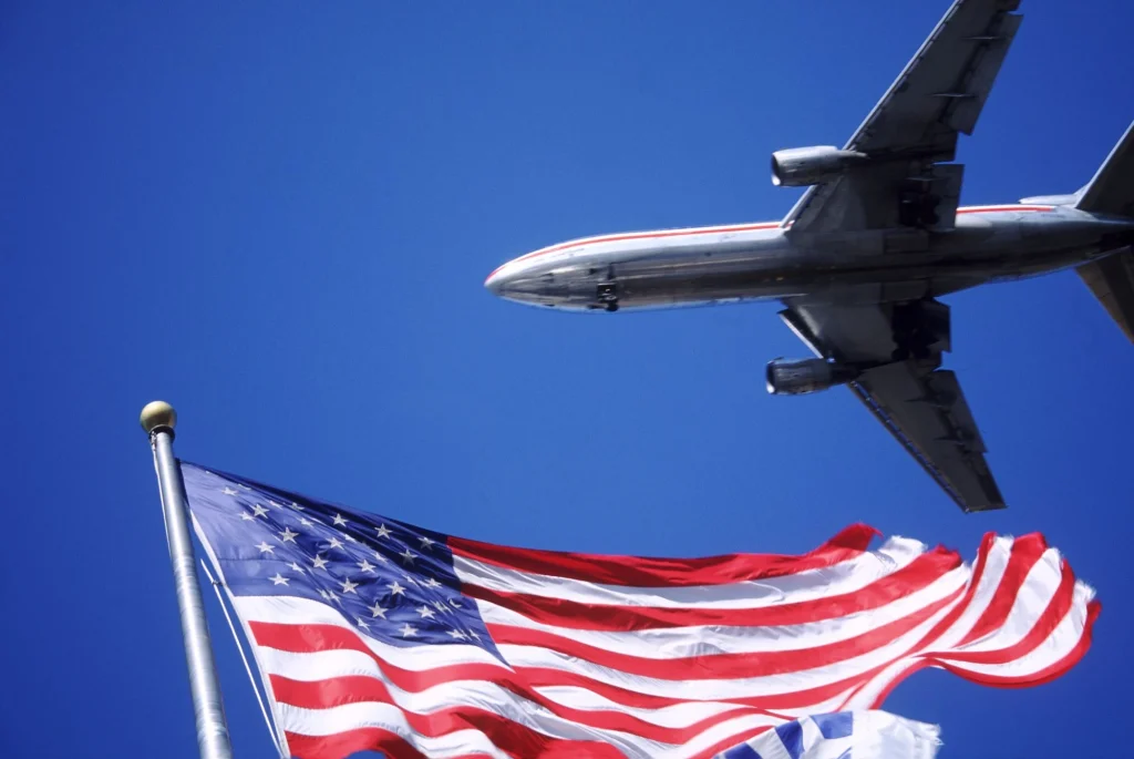 plane flying in the sky over american flag