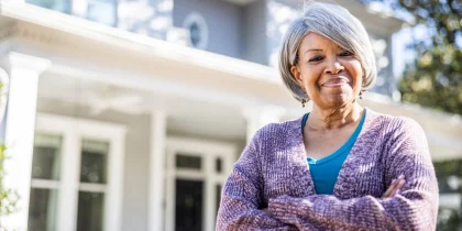 woman standing with arms folded smiling