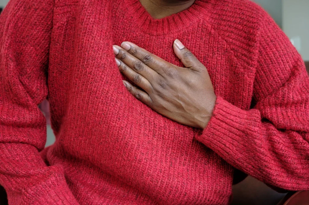 woman clutching chest heart pain