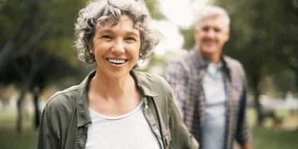 couple walking outside in the park and smiling