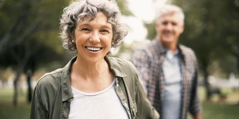 couple walking outside in the park and smiling