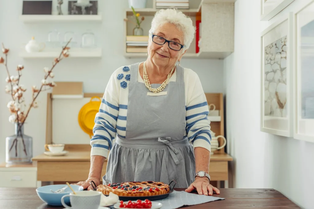 older lady with an apron making a pie