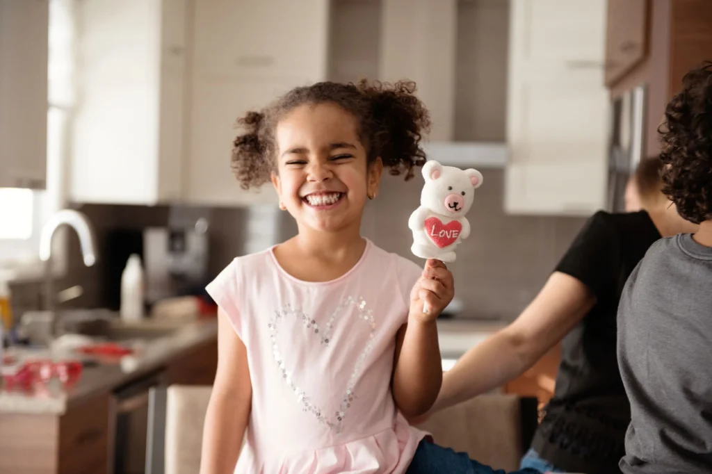 little girl holding bear candy and smiling valentine's day