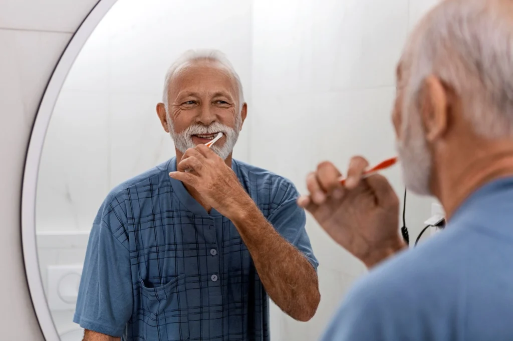 older man brushing teeth