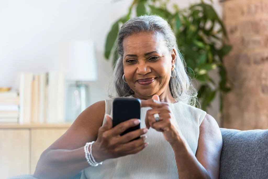 senior woman on her phone sitting on couch