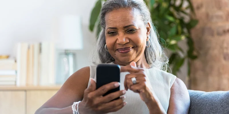 senior woman on her phone sitting on couch