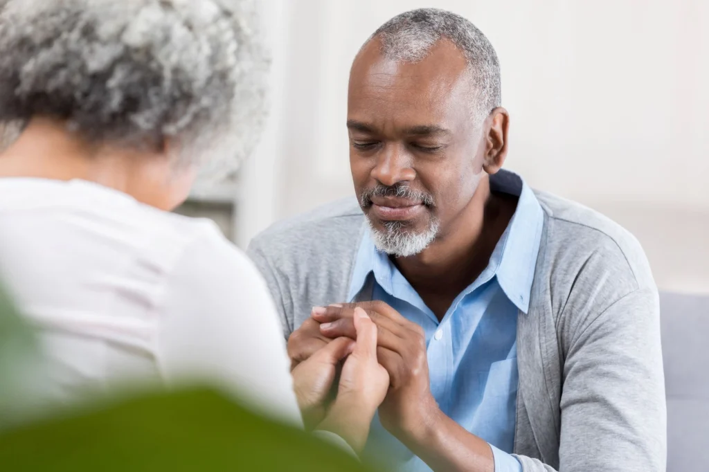 senior man praying for his wife