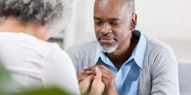 senior man praying for his wife
