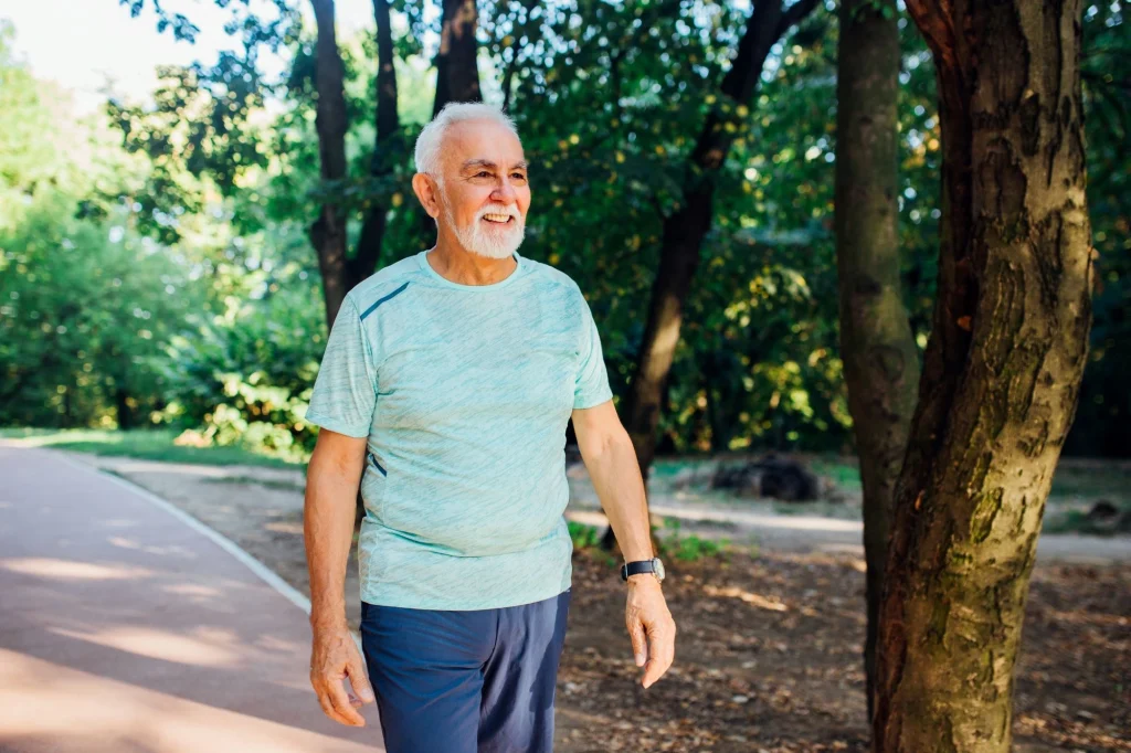 older man walking a trail