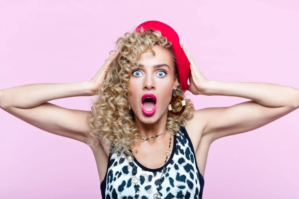 shocked woman gasping and clutching her hat