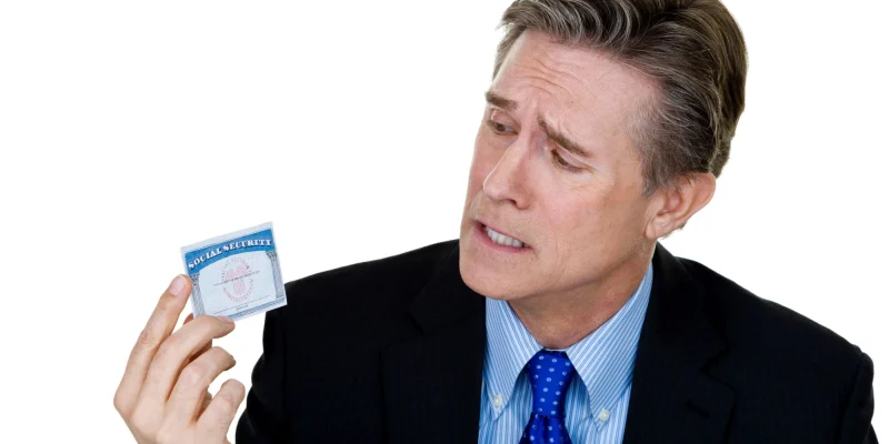 Man holding a social security card looking confused and distraught.