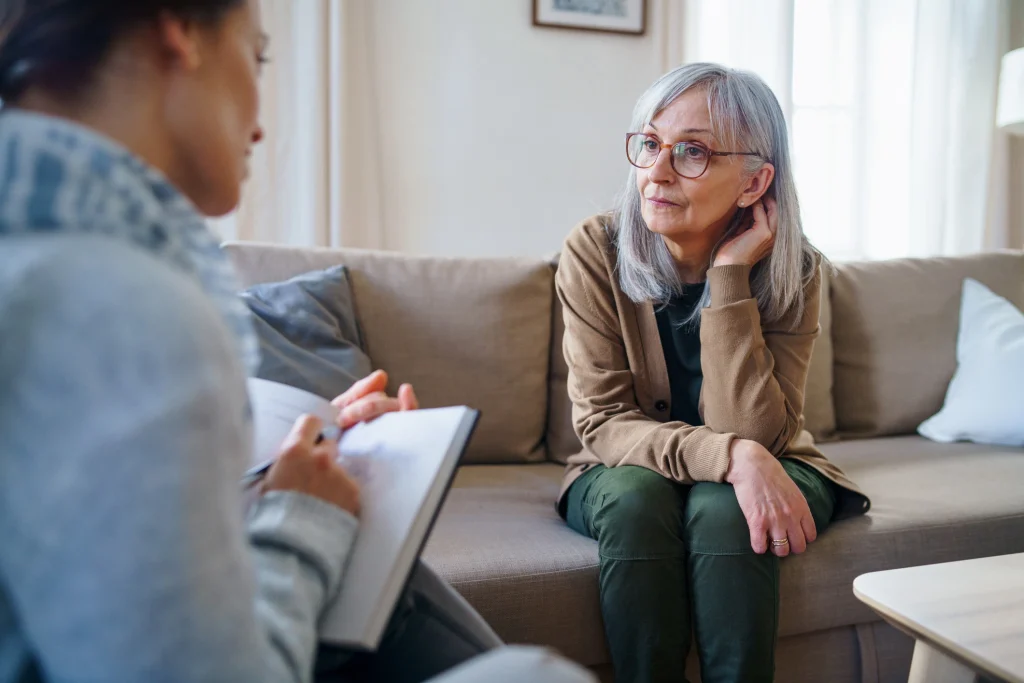 senior woman talking to a therapist or psychiatrist for mental and emotional health
