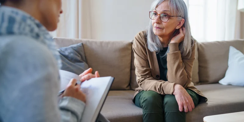 senior woman talking to a therapist or psychiatrist for mental and emotional health