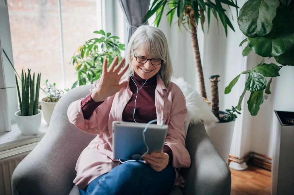 older lady waving at a tablet