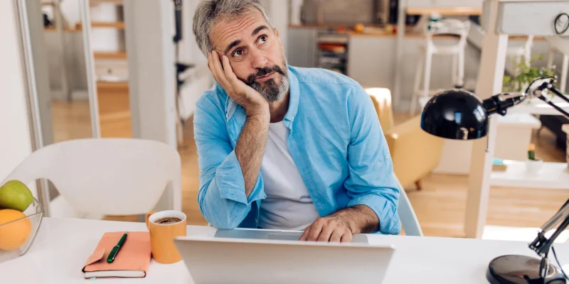 confused older man sitting at desk
