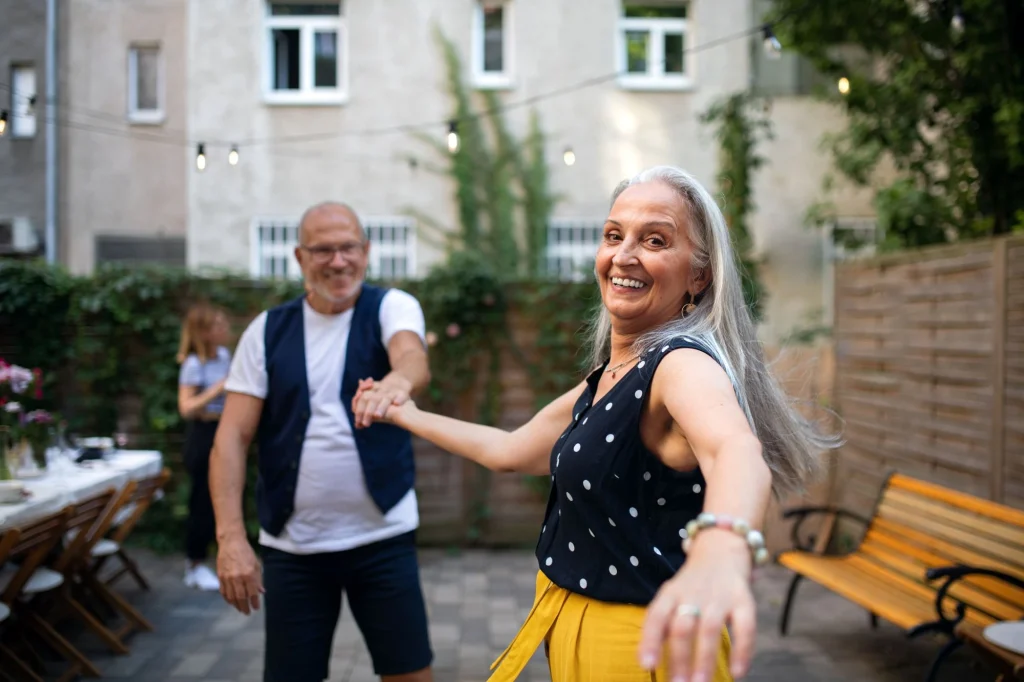 lady and her husband dancing outside on the patio happy and free