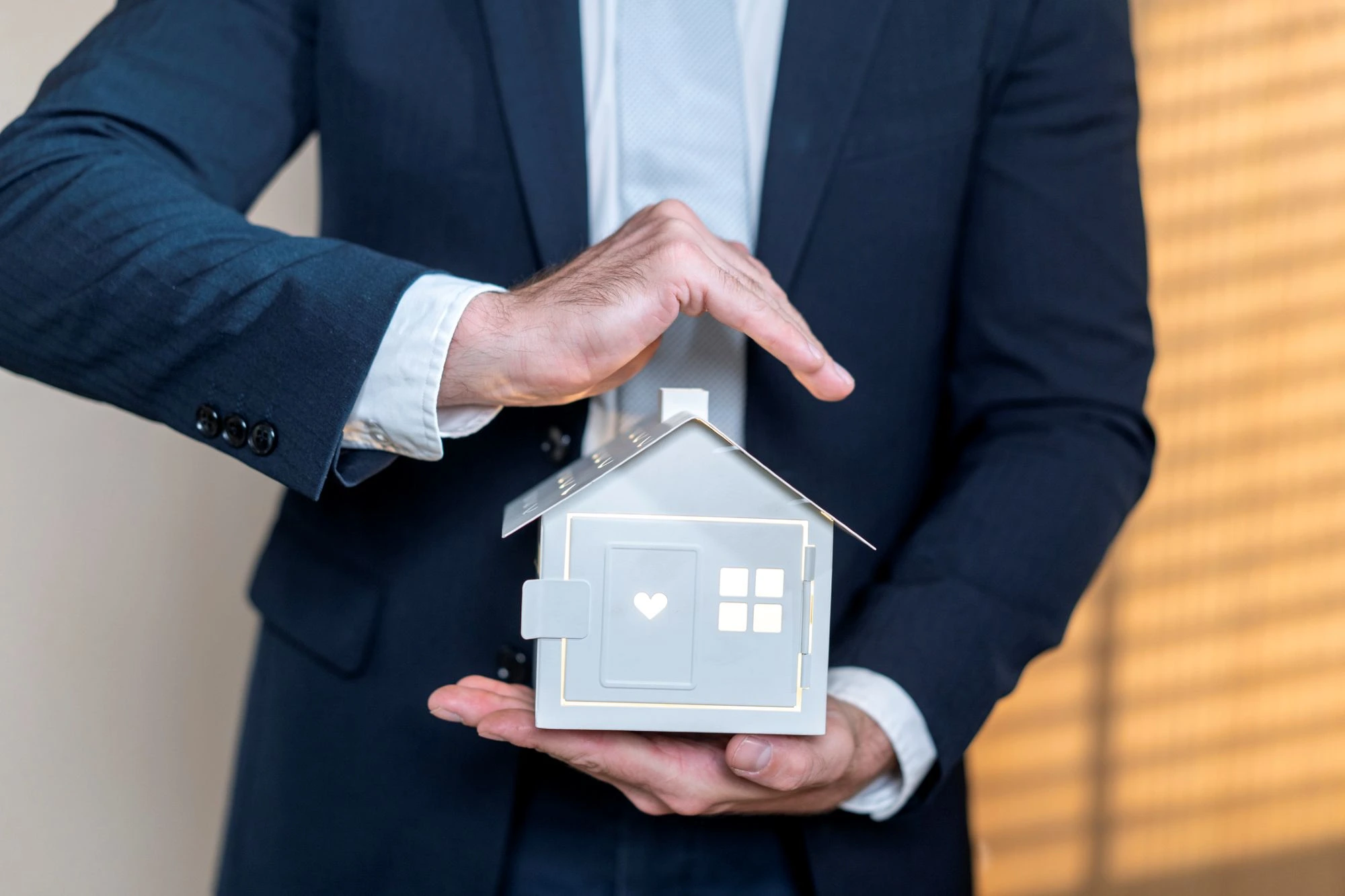 man holding a house realtor in suit