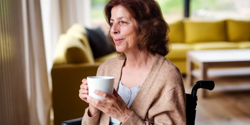 senior woman in a wheelchair drinking coffee