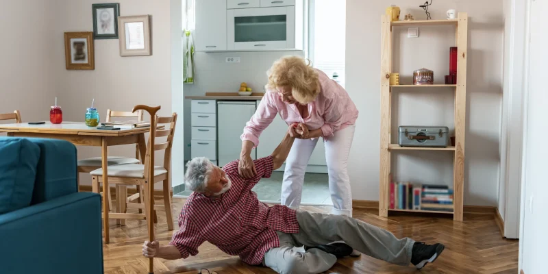 senior man falling and wife trying to pick him up