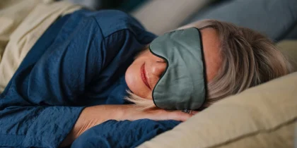 senior woman sleeping in bedroom with a sleeping mask