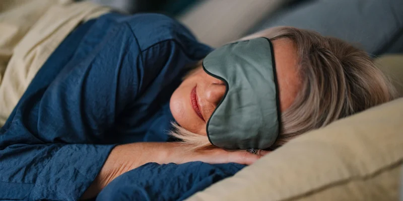 senior woman sleeping in bedroom with a sleeping mask