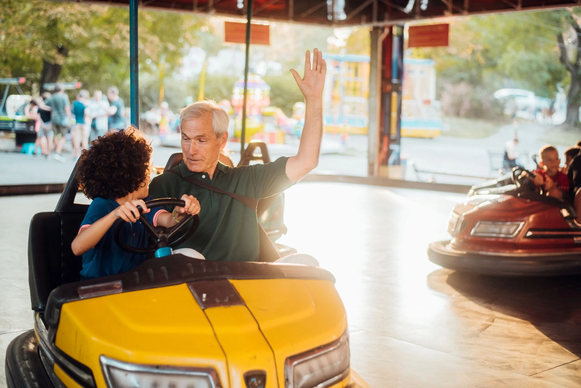 grandpa and grandson doing bumper cars fun at an amusement park